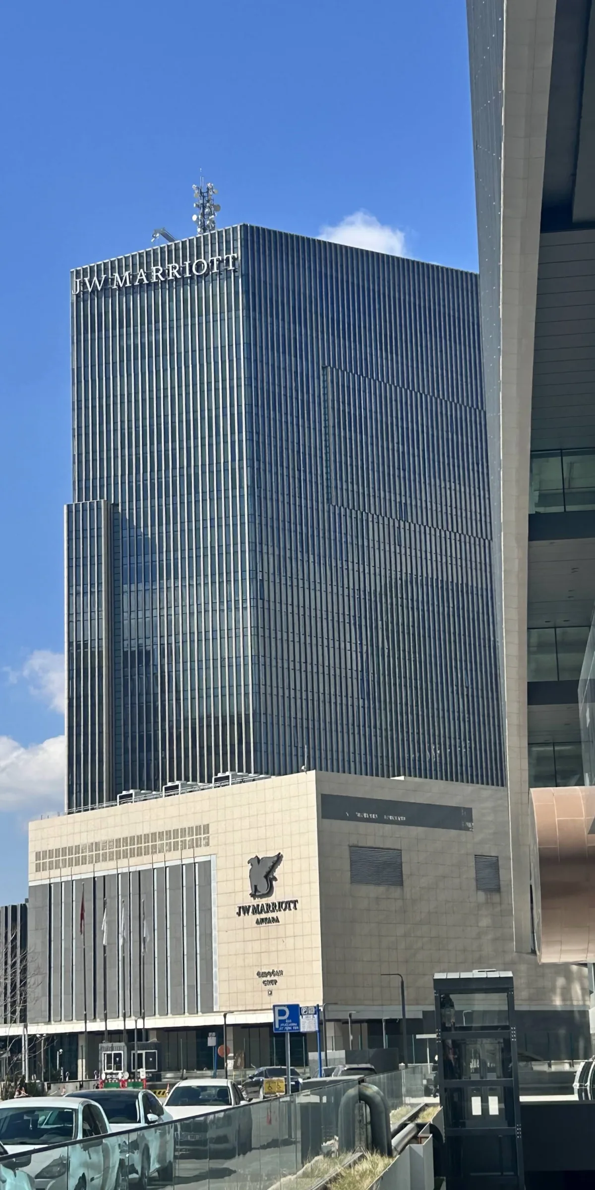 JW Marriott Hotel Ankara tower and street-level entrance under a blue sky