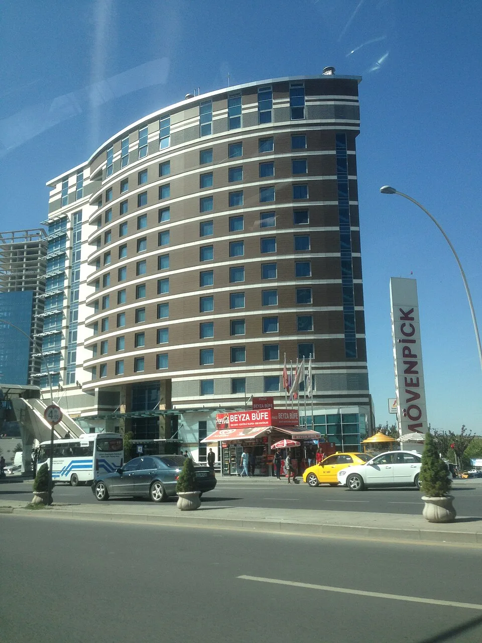 Mövenpick Ankara hotel exterior beside the road, with its curved façade and Mövenpick sign