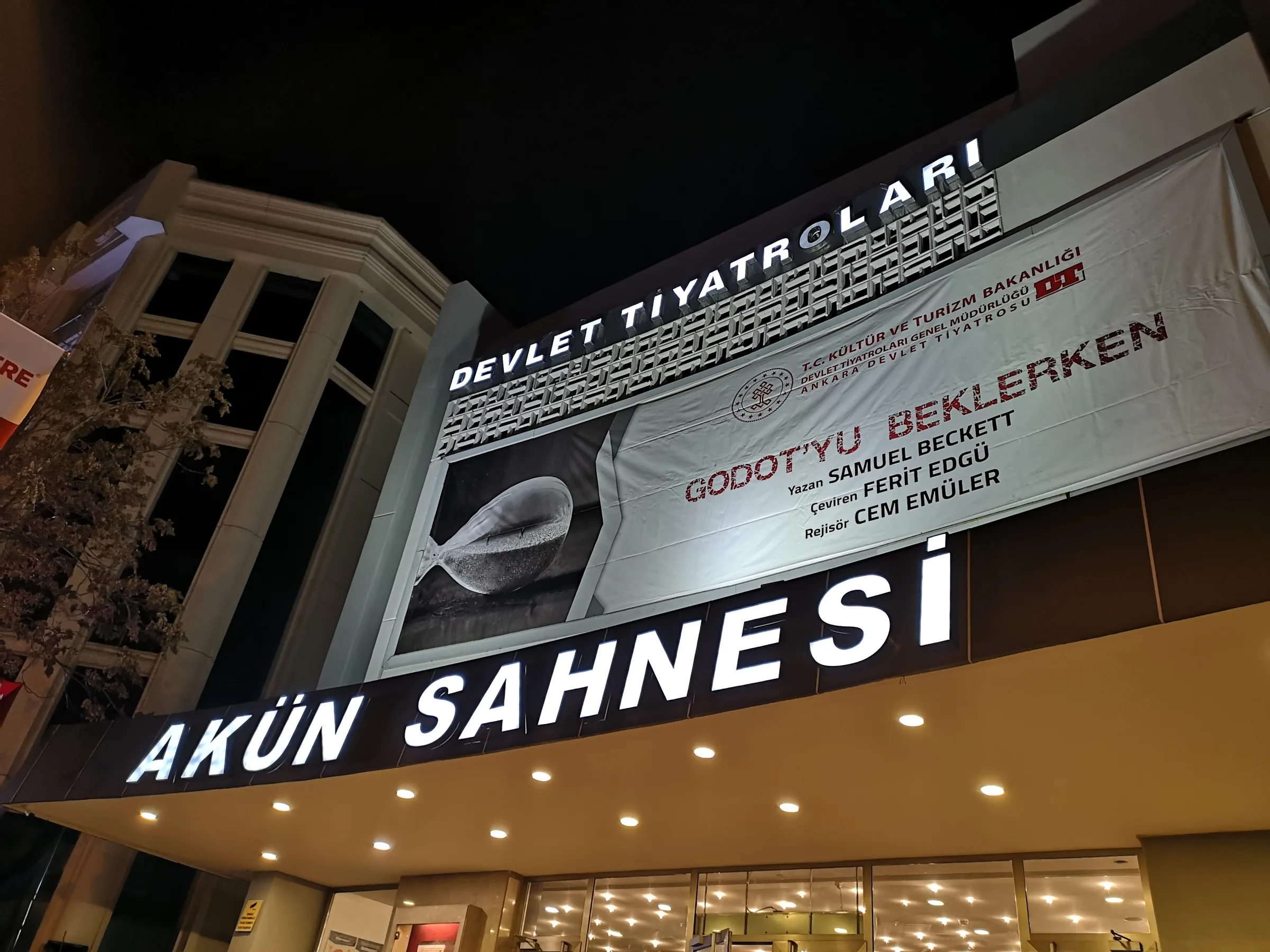 Illuminated Akün Sahnesi entrance and State Theatres signage at night