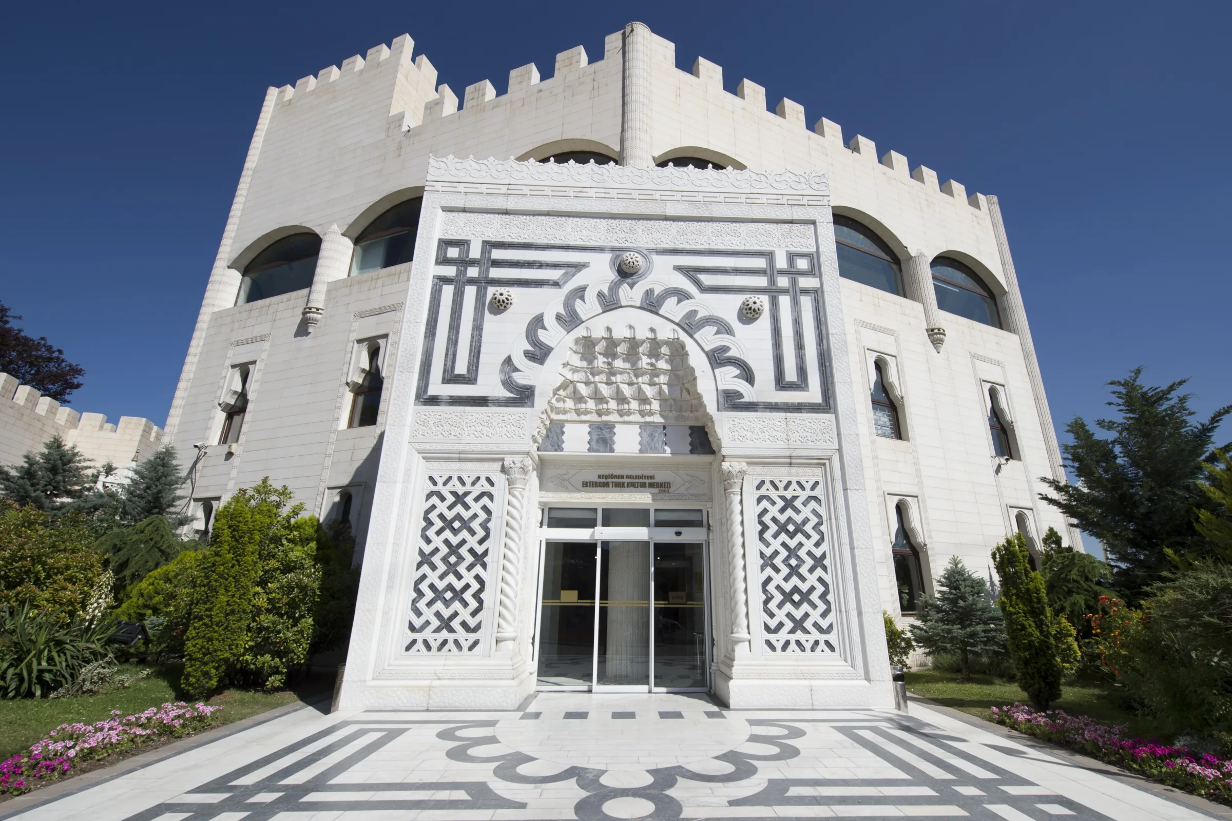 Ornate marble entrance portal and crenellated façade of Estergon Türk Kültür Merkezi in Keçiören