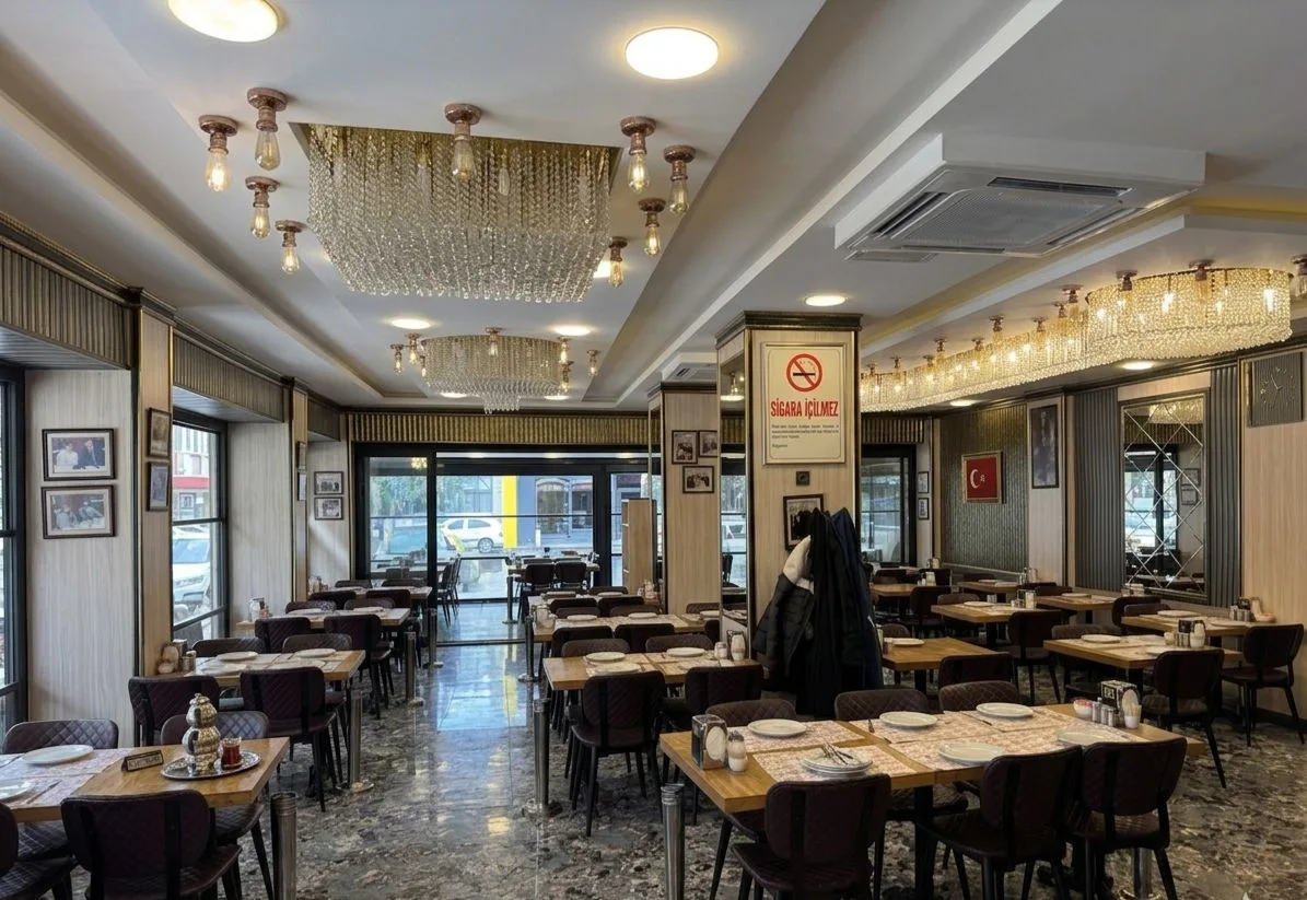 Long dining room with set tables and chandeliers inside Ciğerci Aydın