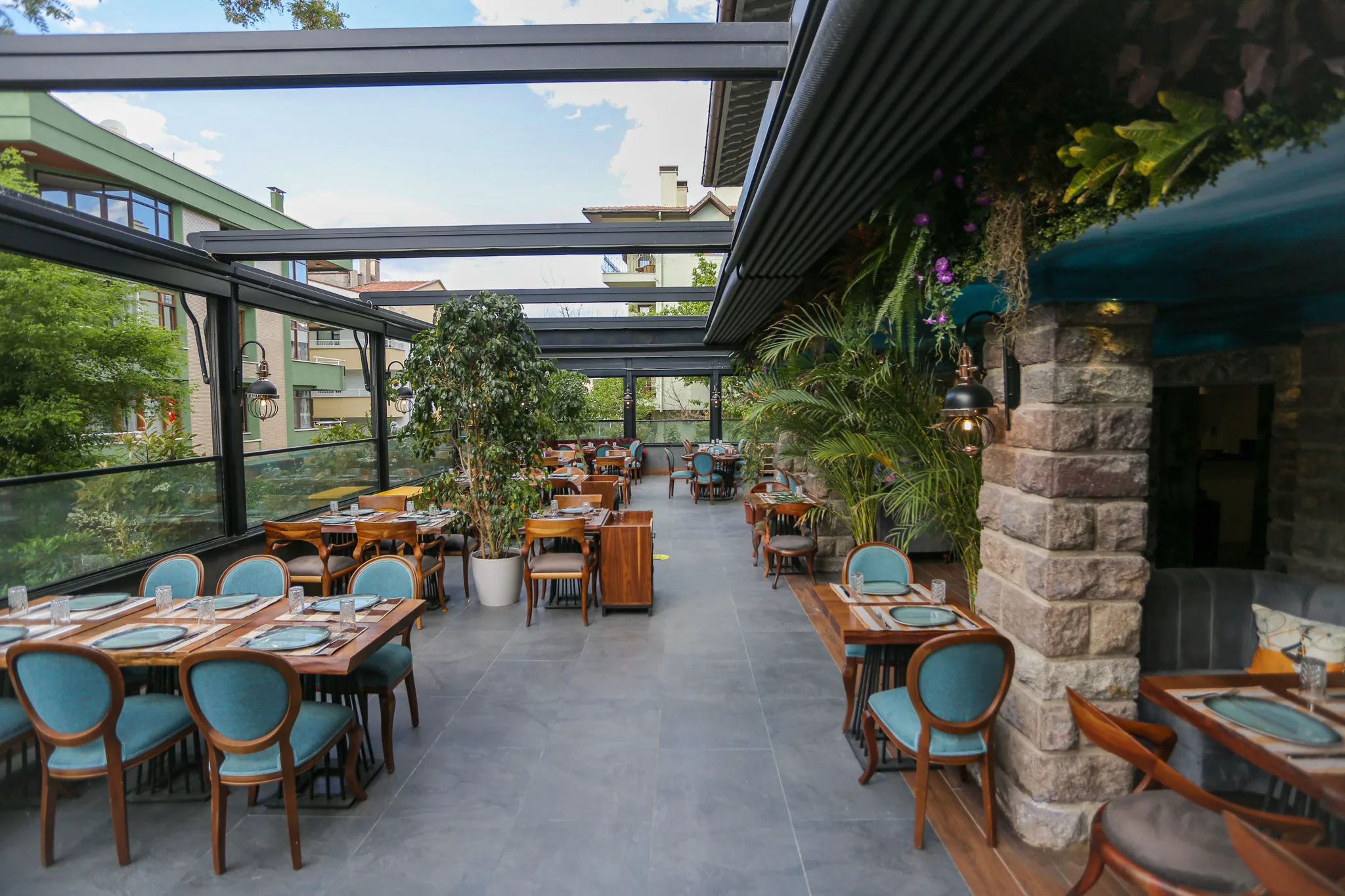 Garden terrace with tables and trees at chef bros