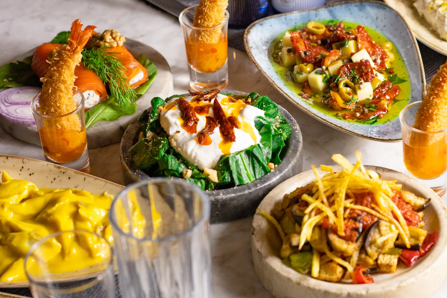 Table of seafood dishes and mezes with glasses of rakı